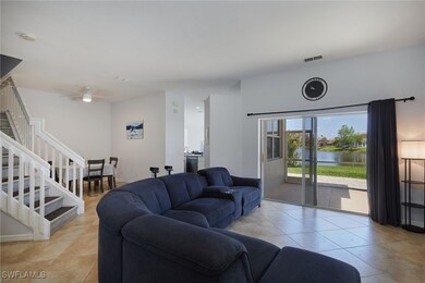 Living room with a water view, stairs, light tile