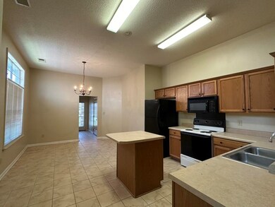 Kitchen with an inviting chandelier, a kitchen isl