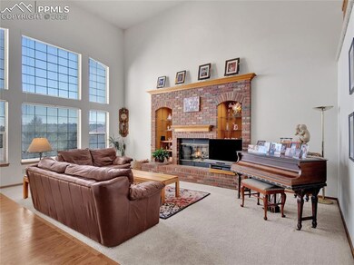Living area featuring a brick fireplace, carpet fl