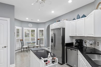 Kitchen featuring appliances with stainless steel finishes, recessed lighting, ceiling fan, white cabinets, and decorative backsplash