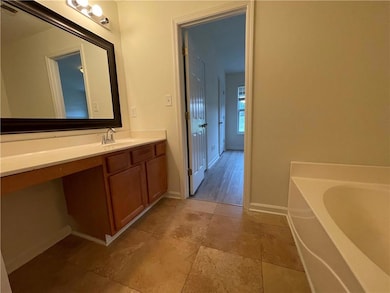 Full bathroom featuring vanity, a bath, and tile patterned flooring