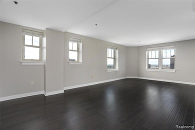 Spare room with baseboards and dark wood-type flooring