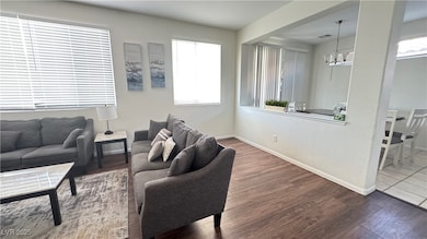 Living room with wood finished floors and a chande