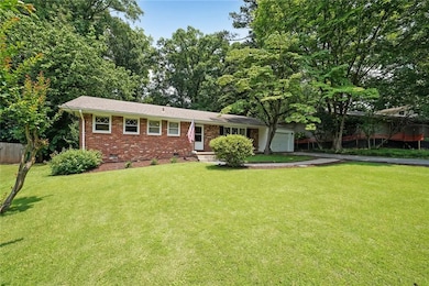 View of front of house with crawl space, brick siding, a garage, and driveway