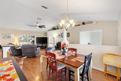 Dining room looking toward living room. Den through double doors to right, Primary suite through arched doorway.