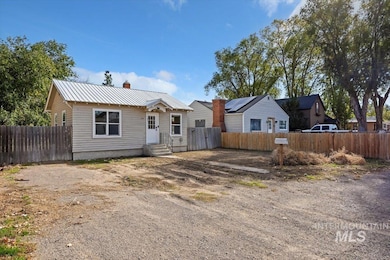 View of front facade featuring a metal roof and a chimney