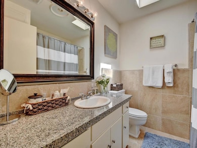 Full bath featuring vanity, tile walls, tile patt