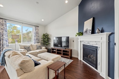 Living room featuring vaulted ceiling, premium fireplace, LVP flooring, recessed lighting
