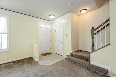 Entrance foyer with carpet, stairs, and ornamental