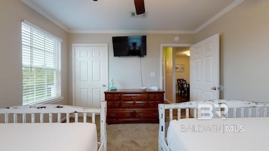 Bedroom featuring crown molding, carpet flooring, a closet, and ceiling fan