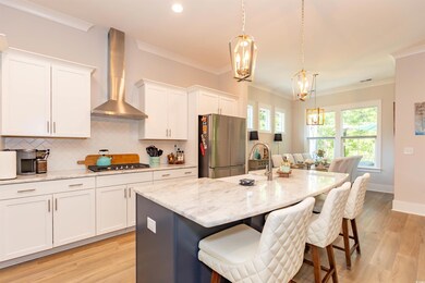 Kitchen featuring wall chimney range hood, stainle