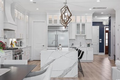 Kitchen with high end appliances, custom range hood, crown molding, tasteful backsplash, and recessed lighting