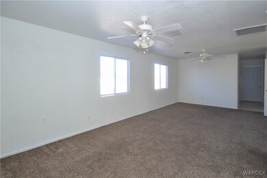 Carpeted spare room featuring ceiling fan