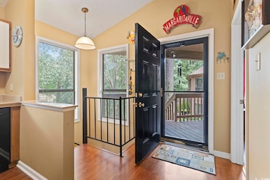 Entryway featuring wood finished floors, lofted ceiling, and baseboards