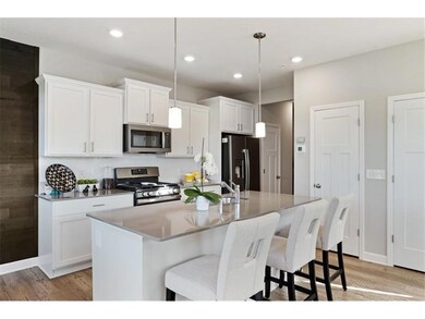 Designer kitchen with white cabinetry, quartz coun