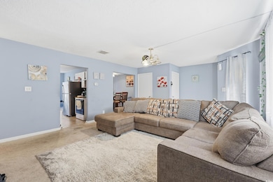 Living area with a chandelier and carpet floors