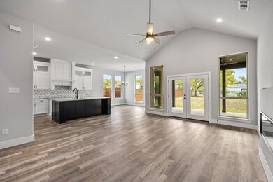 Unfurnished living room with light wood-style floors, recessed lighting, ceiling fan, high vaulted ceiling, and french doors