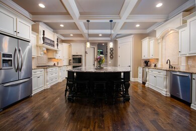 Massive granite island is nearly 7x9 with seating for 5 and two pendant lights, plenty of lower cabinets and storage, as well as stainless microwave.