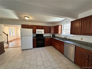 Kitchen featuring sink, light tile flooring, white