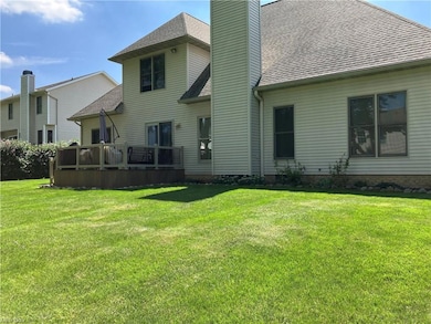 Rear view of house with a yard and wooden deck