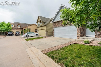 View of front facade featuring concrete driveway, a garage, and stone siding