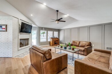 Living room featuring vaulted ceiling, a brick fir