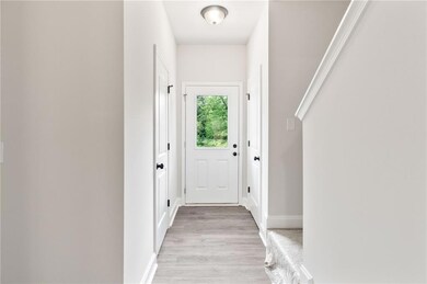 Doorway to outside with light wood-style flooring and baseboards