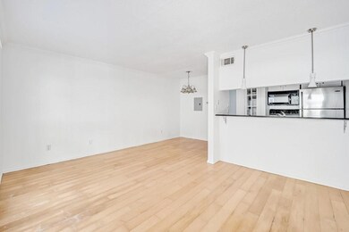 Unfurnished living room with ornamental molding, light hardwood / wood-style flooring, and a notable chandelier