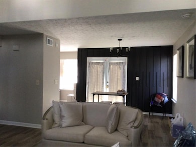 Living area with visible vents, a textured ceiling