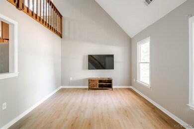 Unfurnished living room with high vaulted ceiling