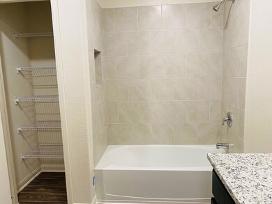 Bathroom featuring vanity, tub / shower combinati