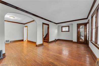Unfurnished room featuring ornamental molding, a wealth of natural light, and hardwood / wood-style floors