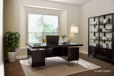 Office with dark hardwood / wood-style floors. Thi