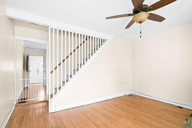 Stairway with hardwood / wood-style floors, baseboards, and a ceiling fan