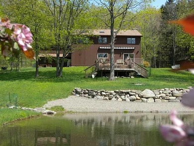 Exterior Front Spring view of the pond, beach, roc