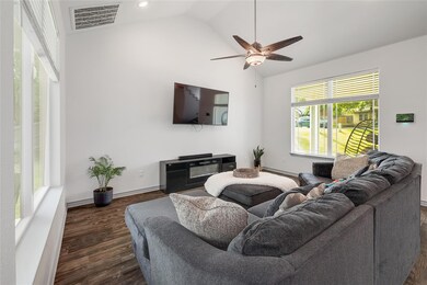 Living area featuring ceiling fan, visible vents,