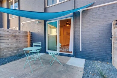 Entrance to property with brick siding and a patio