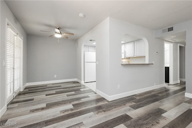 Unfurnished living room featuring a ceiling fan, p
