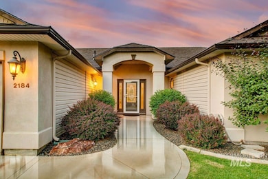 Exterior entry at dusk featuring roof with shingles and stucco siding