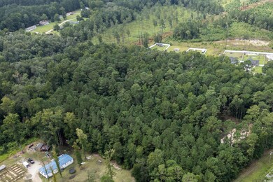 Aerial view of property's location featuring a heavily wooded area