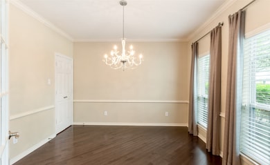 The formal dining room has floor to ceiling windows, chair rail and entry to the kitchen.