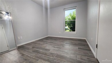 Spare room with dark wood finished floors and baseboards