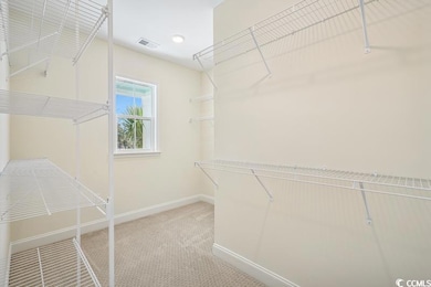 Walk in closet featuring visible vents and light c