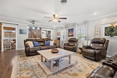 Living room with ceiling fan, ornamental molding,