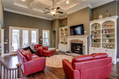 This 24x18 Greatroom features 10 Ft ceilings, French doors to the screened porch,  stunning HW floors, a beautiful coffered ceiling, brick FP w/ custom mantle, and adjacent built in cabinetry and shelving to display your photo's and art.