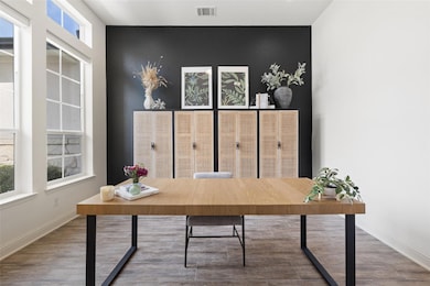 Office space with baseboards, an accent wall, woo
