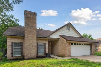 View of front of property with a garage, central AC unit, and a front lawn