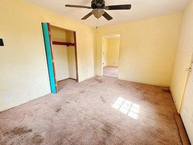 Unfurnished bedroom with carpet, a closet, and ceiling fan