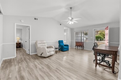 Office with light wood-type flooring, ceiling fan,