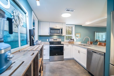 Kitchen with visible vents, a sink, stainless stee